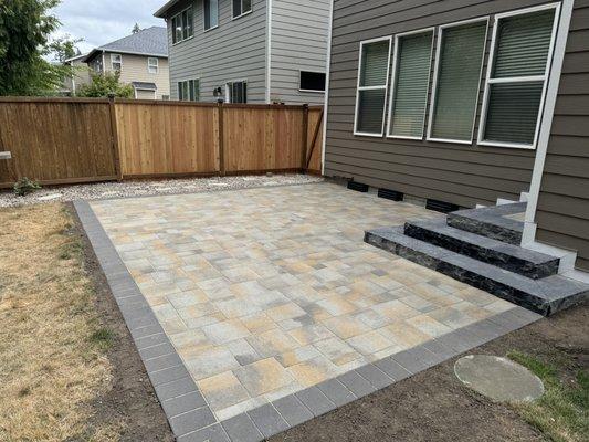 Paver patio with stone steps trimmed out with siding