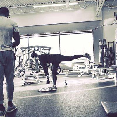 Trainer Ryan Newton working with his client on the reverse deadlift exercise.