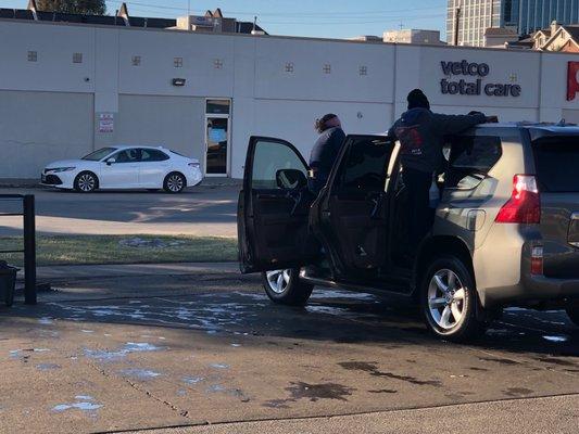 Car wash employees cleaning a car