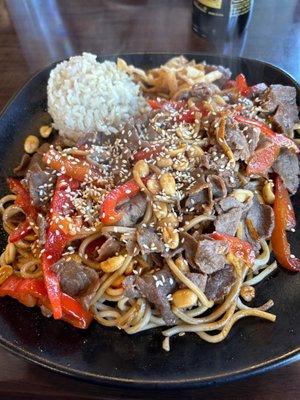 Noodles, beef, red bell peppers, peanuts and brown rice.