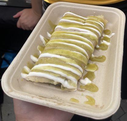 Tamale topped with green salsa and sour cream