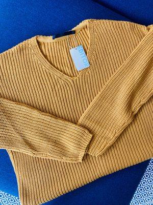 Oversize knitted sweater in a goldenrod color with an Editor tag