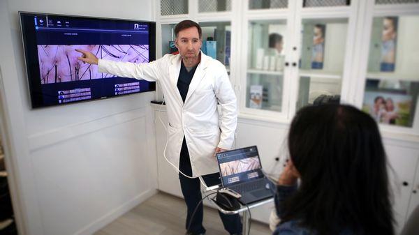 Dr. Tracy reviewing Trichoscopy results to a female patient with hair loss.  This is an essential step to accurate diagnosis.