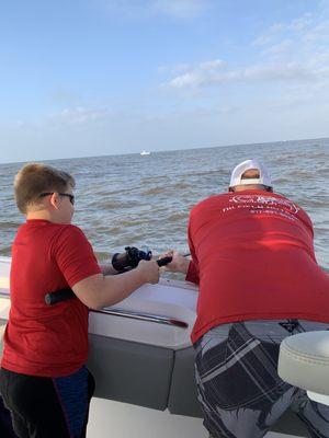 The Captian helping our 9 yr old catch a fish. That made his day.