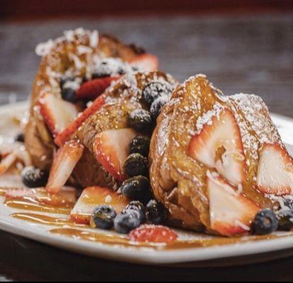 Hawaiian French Toast- Hawaiian Bread, French Toast Battered, Coconut Shavings, Strawberries, Blueberries, Caramel & Powdered Sugar.