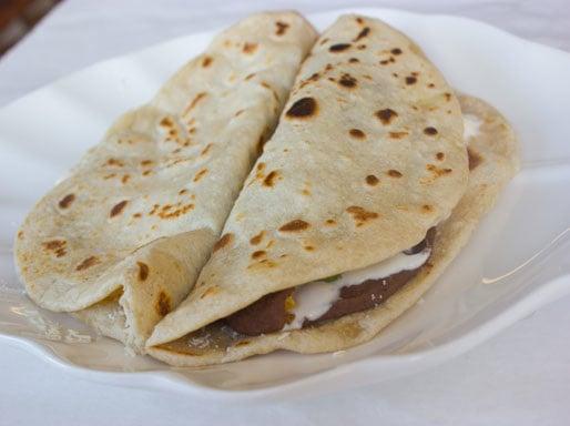 Baleadas a honduran kind of flour tortilla  with cheese refried beans and sour cream..