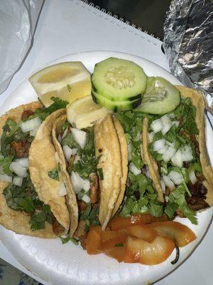 Two tripa tacos, cabeza taco in the middle, and pastor taco at the end