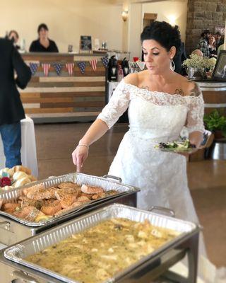 Bride dishing up our Award Winning Lemon Dill Salmon served with our Signature Dill Sauce