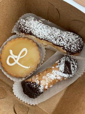 (Clockwise) Whipped cream eclair, cannoli, lemon tart