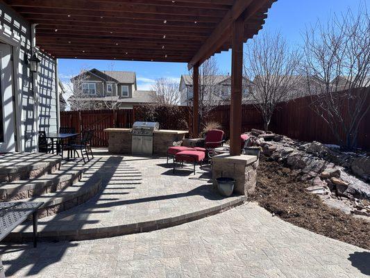 New Paver patios with pergola, outdoor kitchen, and waterfeature in Aurora CO