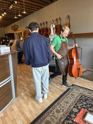 Staffer Ben Arnett about to look over a customer's cello.