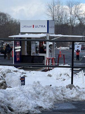 Beer stand in parking lot near bridge