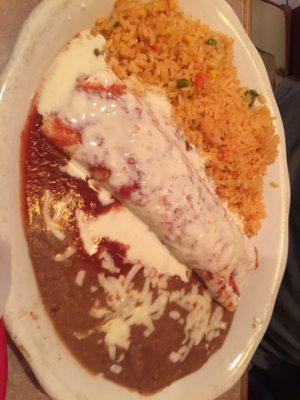 A beef burrito, with both red sauce and queso, with rice and beans