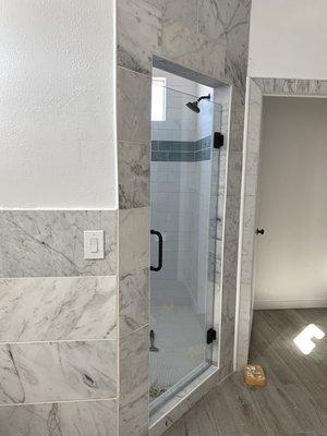 Subway with blue accent installed in master bathroom along with marble surround.