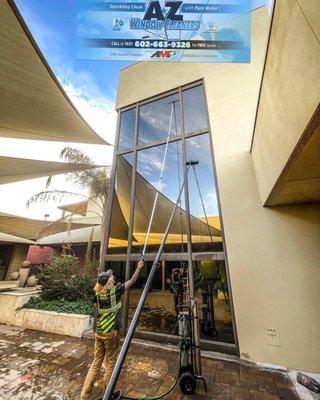 Professional Window Cleaning crew using a water fed pole to get those hard to reach windows.