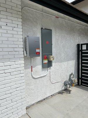 Main panel upgrade installed cleanly next to the Enphase combiner box. Can see the stucco wasn't blended exactly perfect!