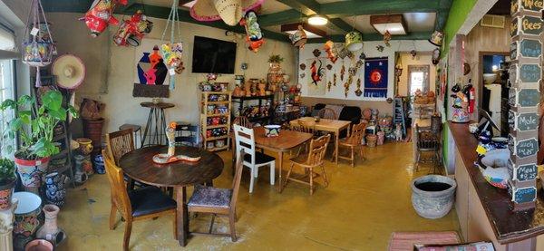 Cozy café with Talavera pottery on shelves and walls.