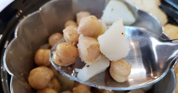 Step 2 of pani puri creation... scoop up some potato and chickpea filling