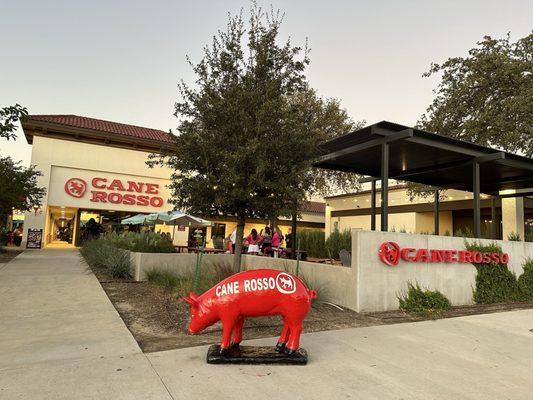 Cane Rosso faces Arapaho Road on the North side of the street, west of Hillcrest Road.