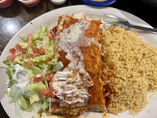 Grande Beef Burrito served with Rice and lettuce, tomato and sour cream! It was topped with nacho cheese!