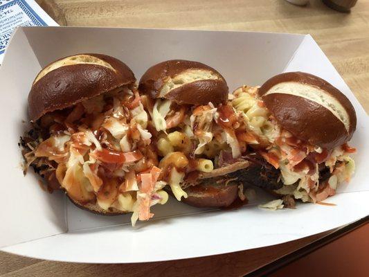 Three little piggys. Bbq pulled pork topped with a homemade coleslaw and macaroni and cheese on a fresh pretzel bun! Delicious!