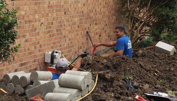 Crew at work digging tunnels to install concrete piers through an exterior breakout.