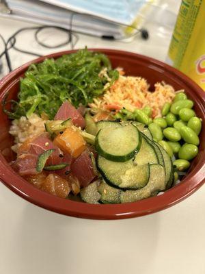 Medium poke bowl with sushi rice (at the bottom) with ahi tuna, salmon, spicy crab, cucumber, edamame and goma wakake  (seaweed salad)!