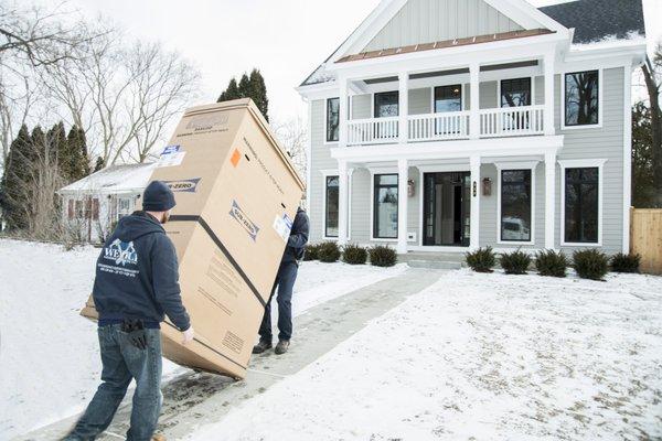 Carrying the new refrigerator into the house.