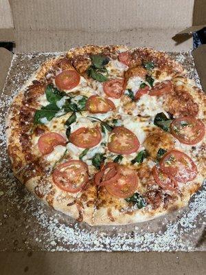 Build your own pizza with tomatoes, spinach, and onion, with Parmesan crust