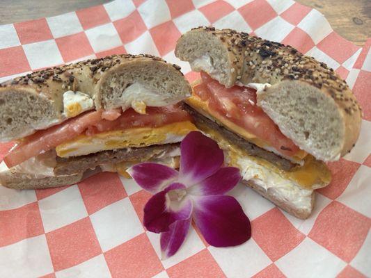 Toasted everything bagel with cream cheese, sausage, egg, and tomato.