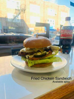 Fried Chicken Sandwich with polvorone cheese, pickles, tomatoes, and lettuce on a brioche bun