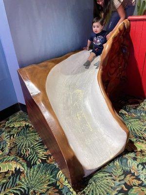 One of the 3 kiddie slides in the toddler area. My daughter helping him.