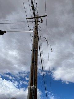 Loose wires off pole that they just leave there, with whole pole looking like a mad scientist experiment!