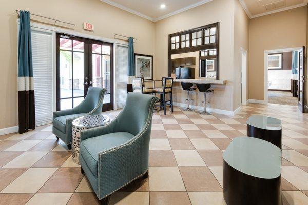 Clubhouse with arm chairs and kitchen.