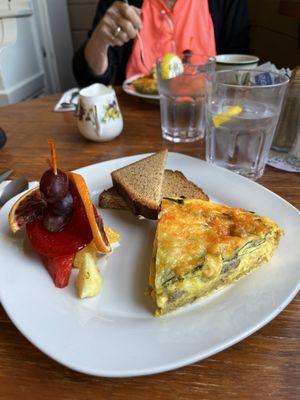 Spinach and sausage quiche with fresh fruit and banana bread.