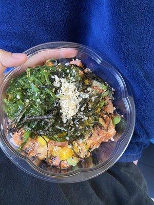 Bowl with rice, salmon, coconut cream, massago, mango, edamame, seaweed salad, cucumber, macadamia nuts