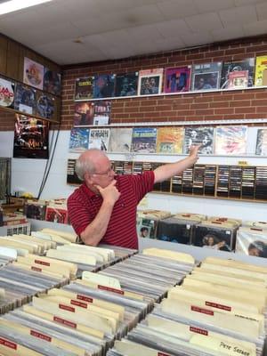 John showing the collection of records on the wall