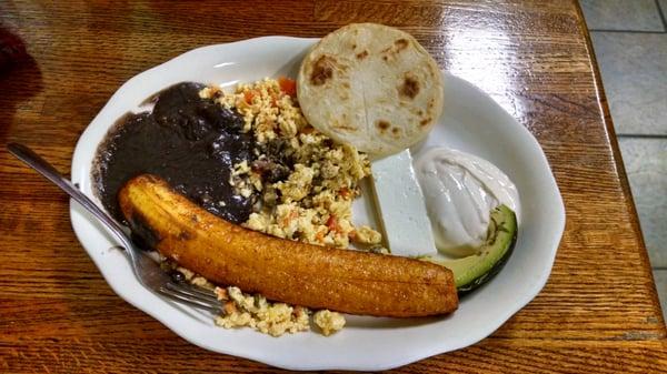 Tipico Salvadoreño breakfast: scrambled eggs w/ tomatoes & onions, refried beans, cheese, avocado, fried plantain, sour cream, and tortillas