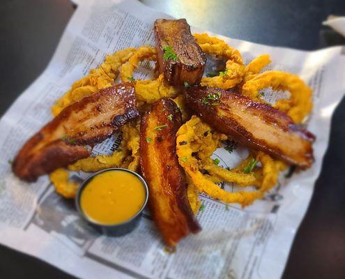 Pork belly on a bed of onion rings with Habeñero BBQ sauce