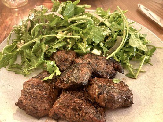 Steak tips with arugula salad.