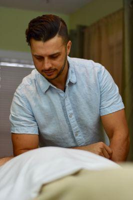 Jason Mayfield, Licensed Massage Therapist, demonstrating deep tissue work.