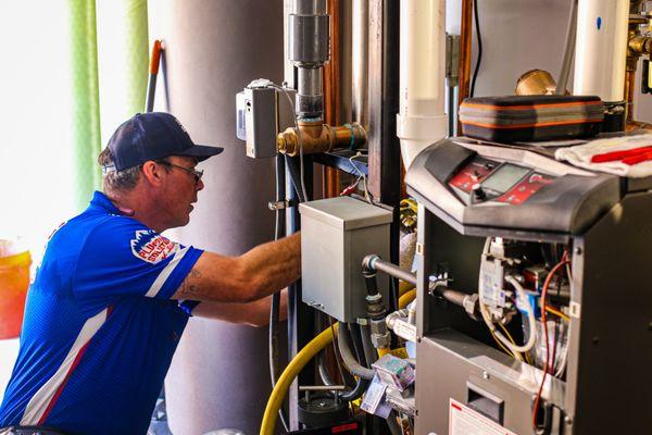 Our skilled technician performing routine maintenance on a boiler, ensuring it runs efficiently and safely.