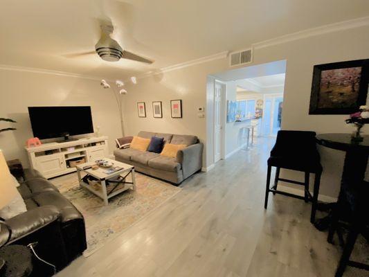 Living room area looks bigger with light walls and ceiling. Perfectly installed new crown molding and doors.