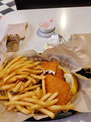 Fish and chips and fries with fresh cut lemons and tartar sauce