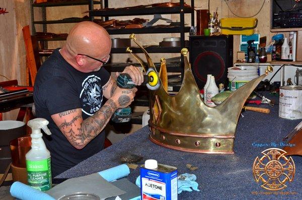 Kings Of Canna logo crown made with 32oz dark brass and copper accents. This is the owner of the shop doing some extra polishing work.