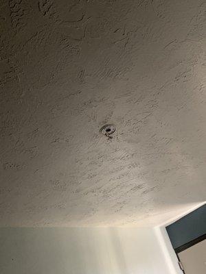 Wire hanging down where smoke detector is supposed to be.