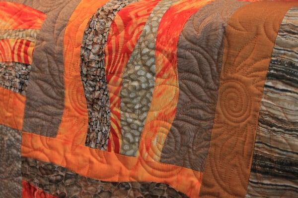 the quilting pattern here adds a great texture; the fireflower motif echoes the piecing and adds movement to the finished top