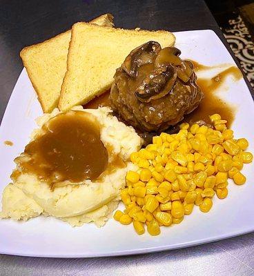 The "Chopped Steak Dinner" with Mashed Potatoes, Mushroom-Beef Gravy, Yellow Corn, and Bread.