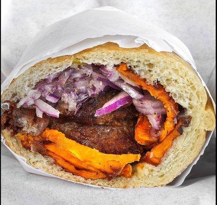 Carnita sandwich, pork chunks, sweet potatoes, marinated onions, pan con chicharrón