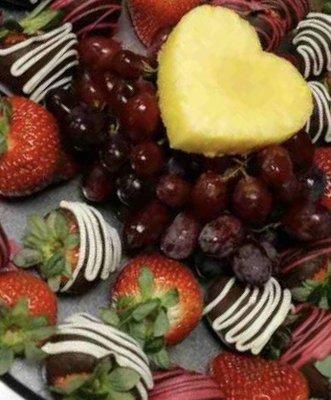 Chocolate covered strawberries with color chocolates, grapes and pineapple